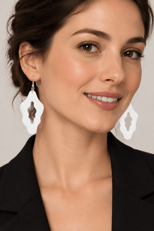 Femme adulte portant des boucles d’oreilles blanches organiques ajourées