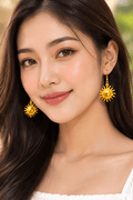 Jolie femme thaïlandaise portant la boucle d'oreille Roi Soleil